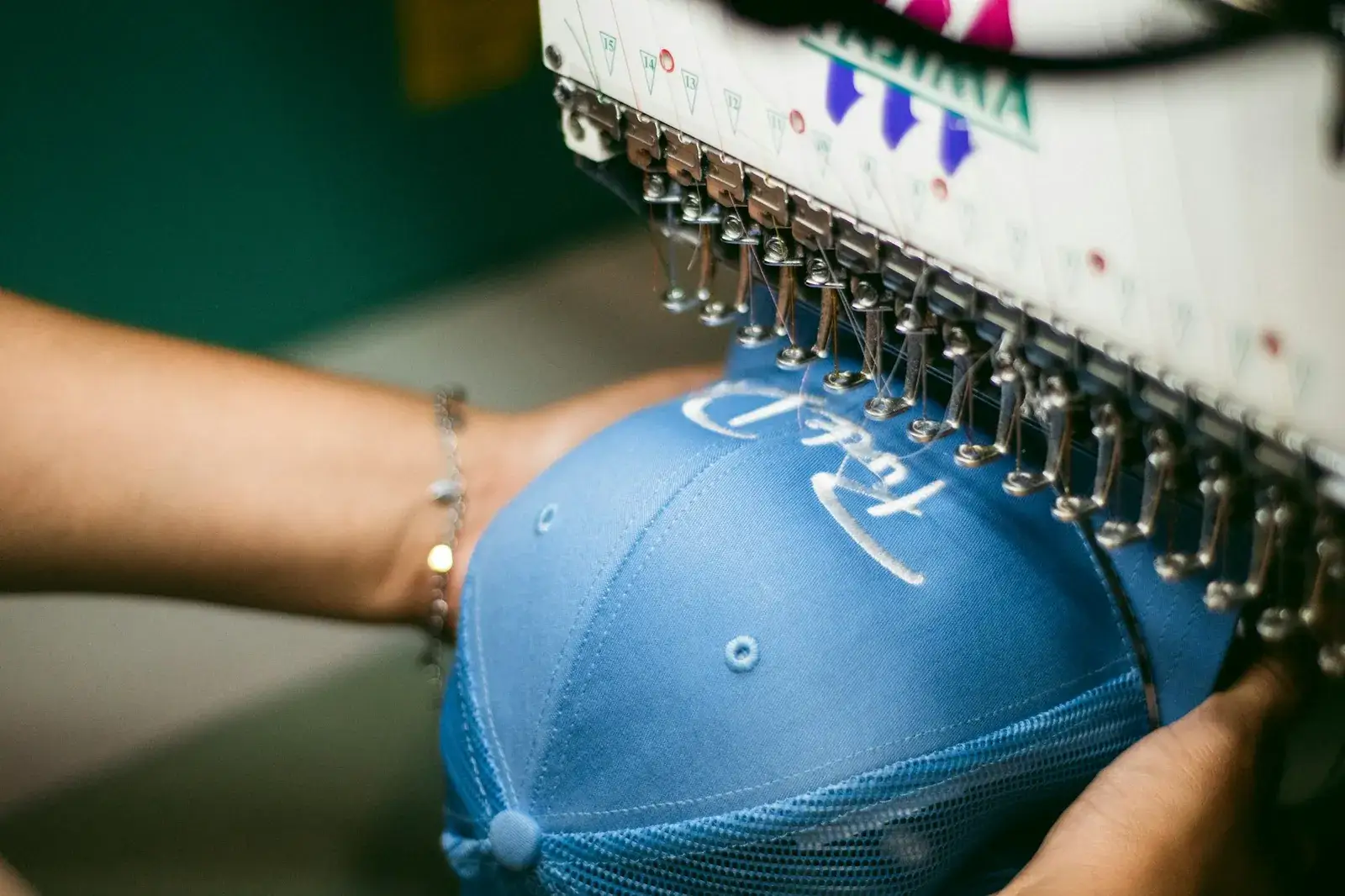 Broderie d’une casquette bleue sur une machine à broder