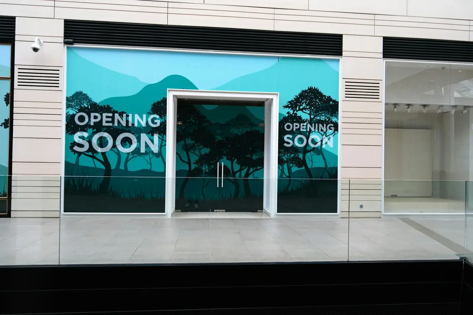 Vitrine d’un magasin habillée d’un visuel adhésif annonçant une ouverture prochaine