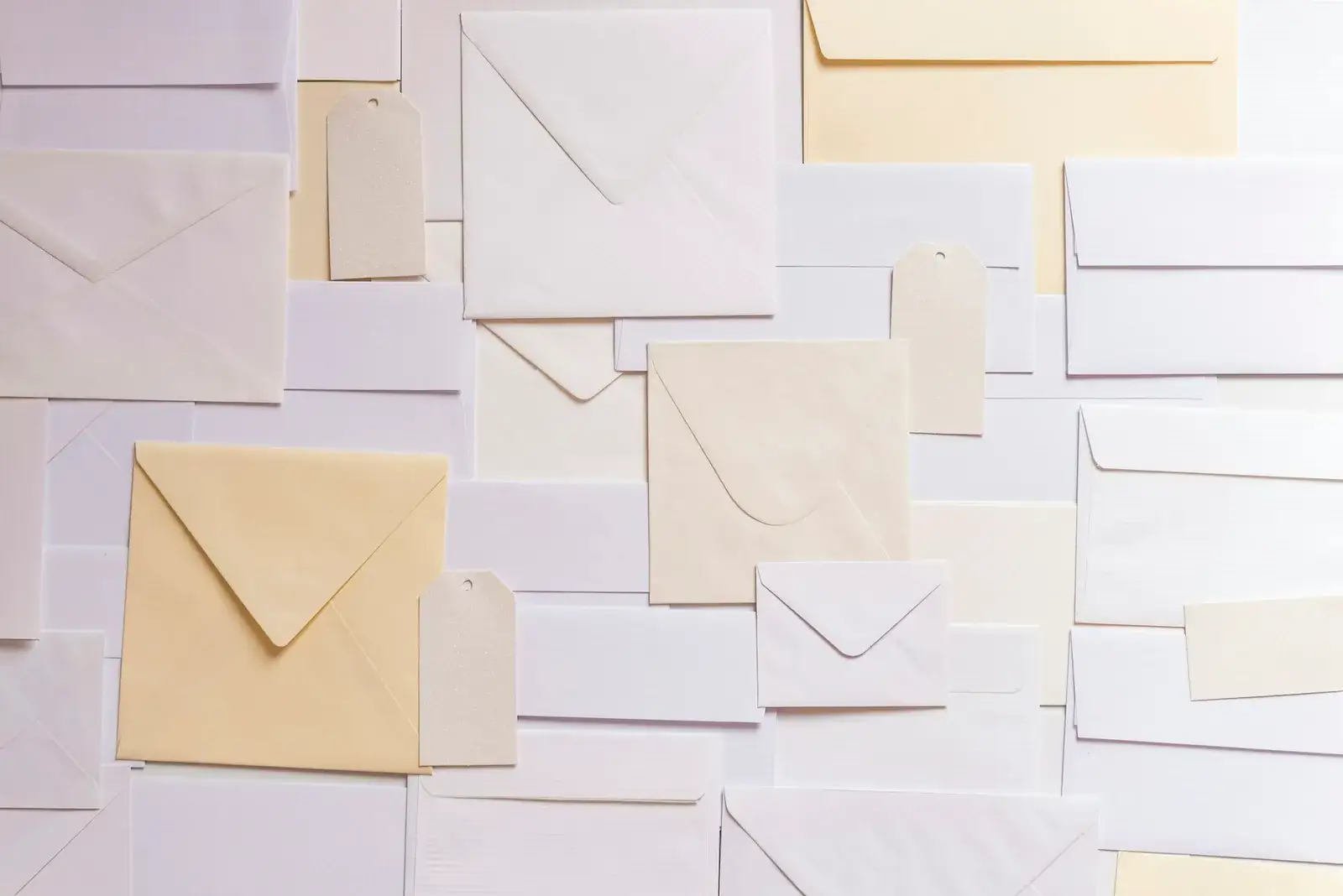 Enveloppes de couleurs pastel disposées sur un fond clair