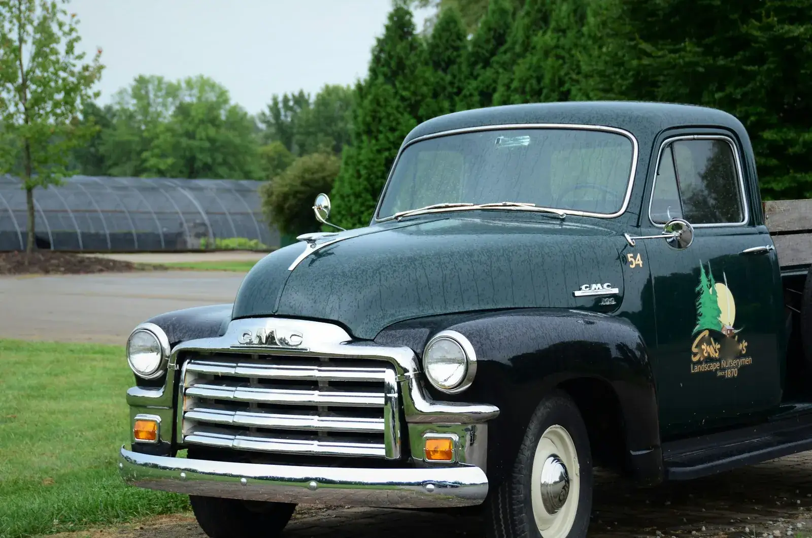 Pick-up ancien noir aux chromes brillants, avec un logo d’entreprise sur la portière