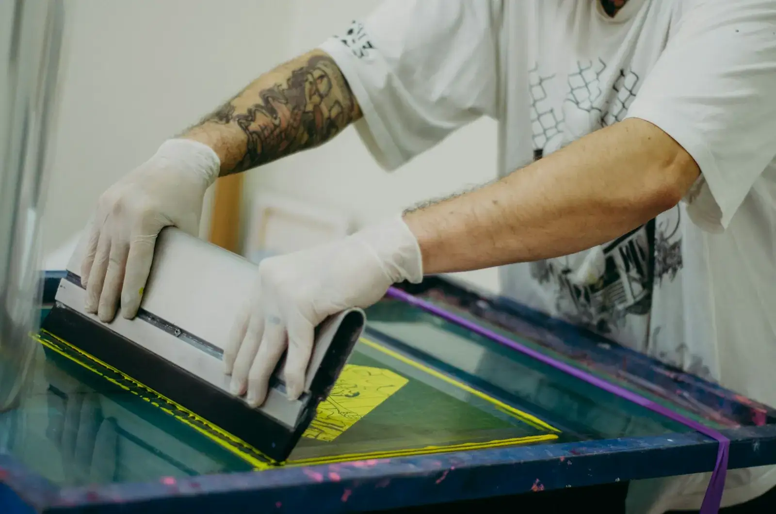 Impression sérigraphique sur textile : la racle est passée sur le cadre