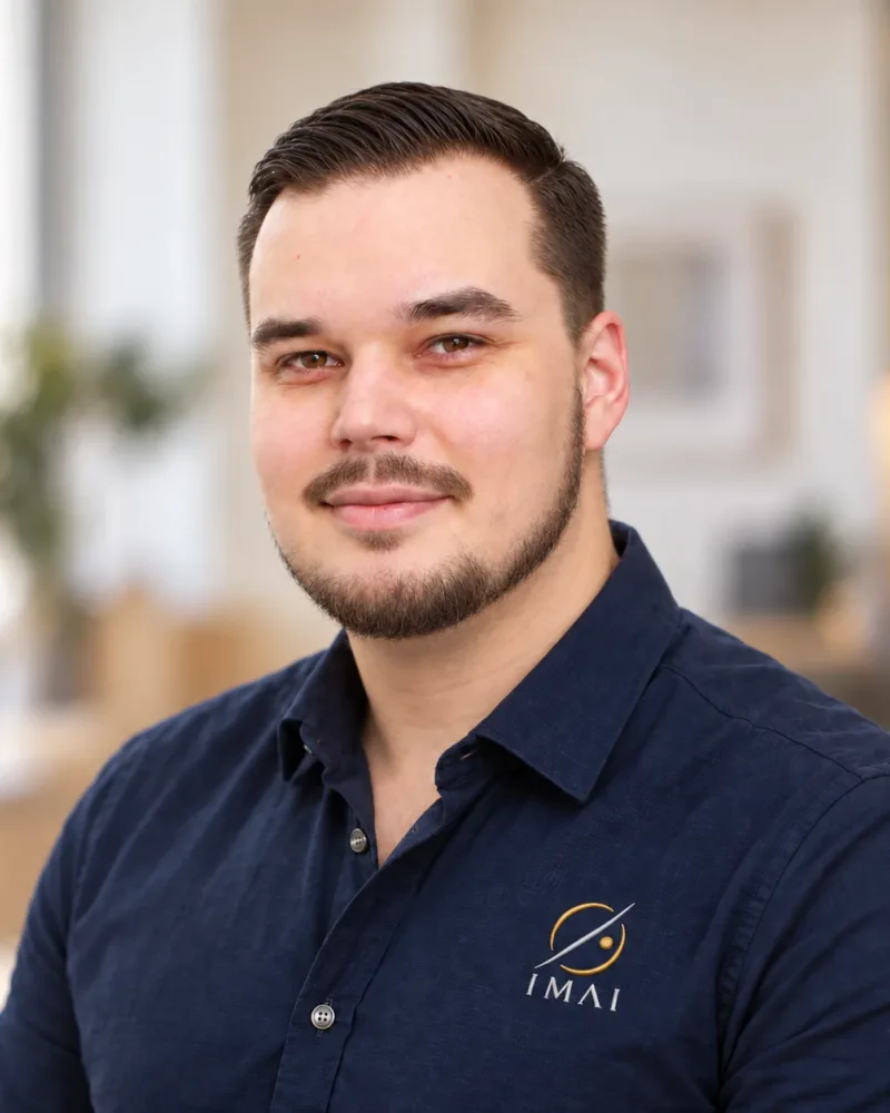 Portrait de Tristan Nais, en chemise bleu marine brodée du logo IMAI